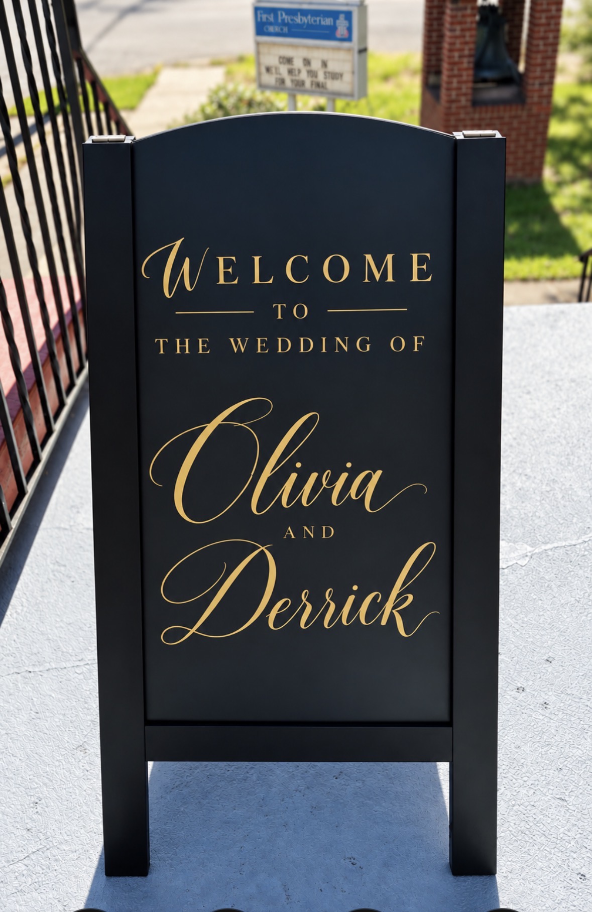 Black and gold personalized wedding welcome sign displayed outdoors