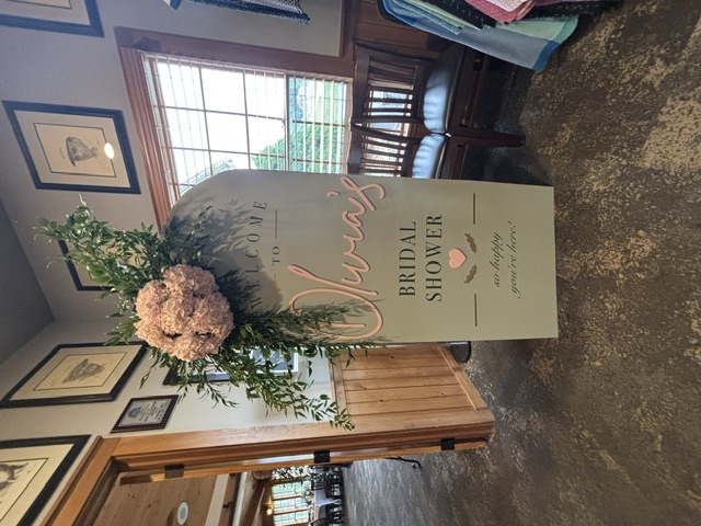 Personalized sage bridal shower welcome sign styled with hydrangeas and greenery