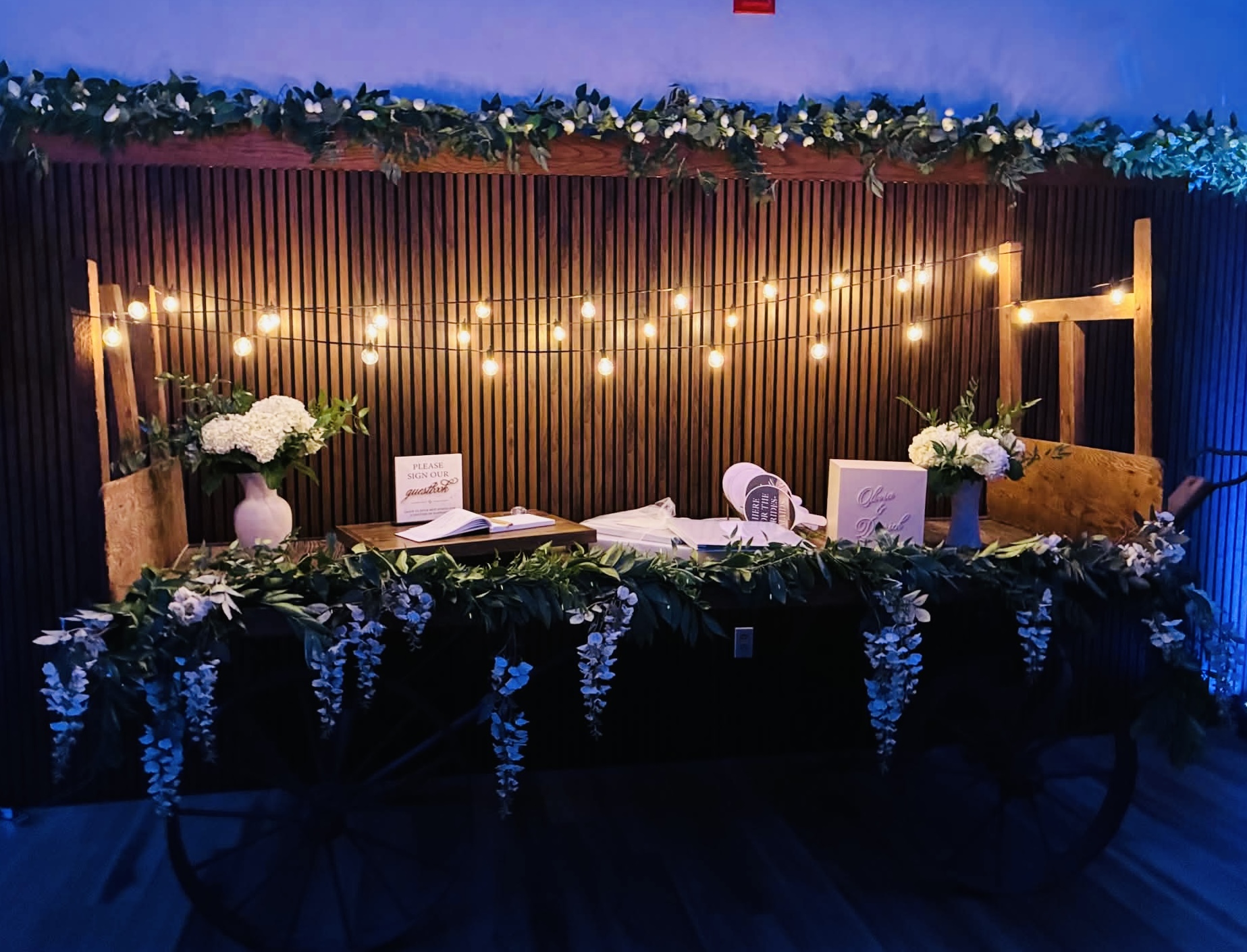 Warmly lit guest-book and memorial display arranged on a rustic wooden wagon